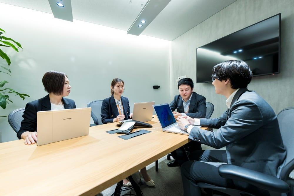 会議室で打ち合わせをするメンバー