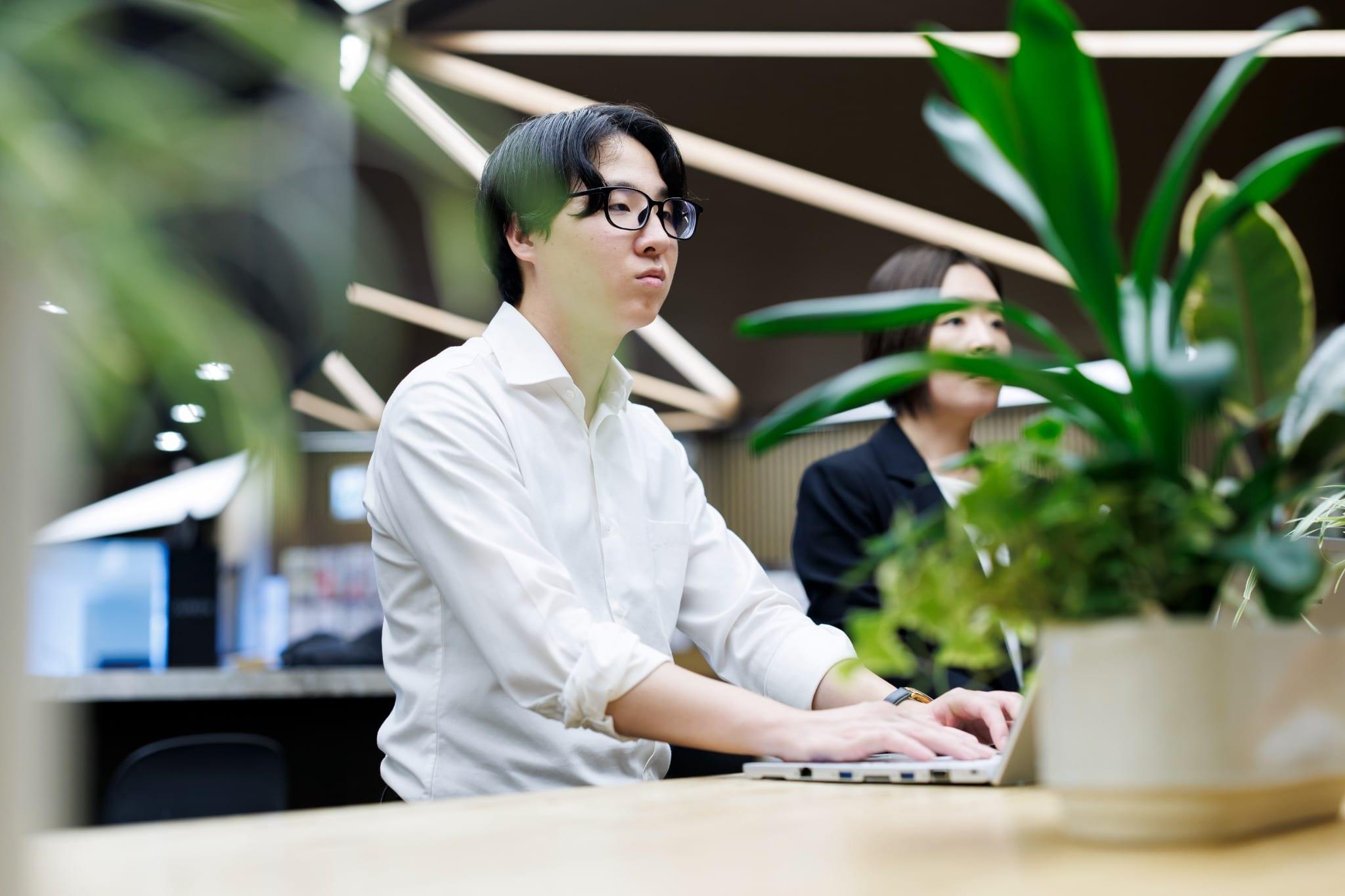 オフィスでノートPCに向かうR.Tさん